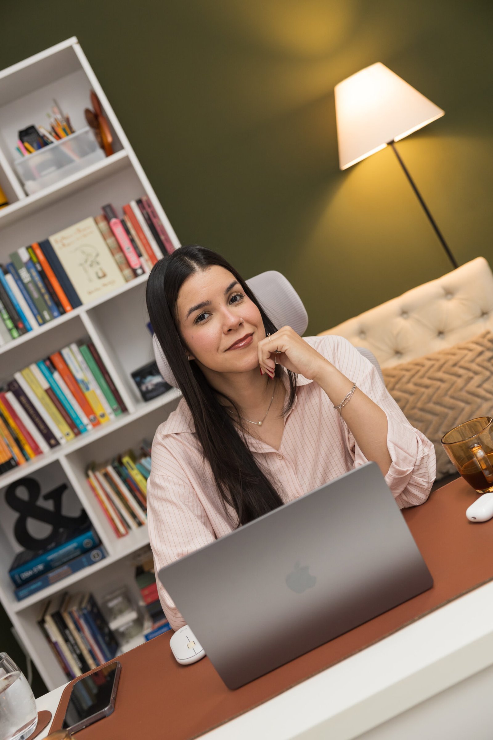 Mariana Nascimento, psicóloga, trabalhando em um notebook em seu consultório.